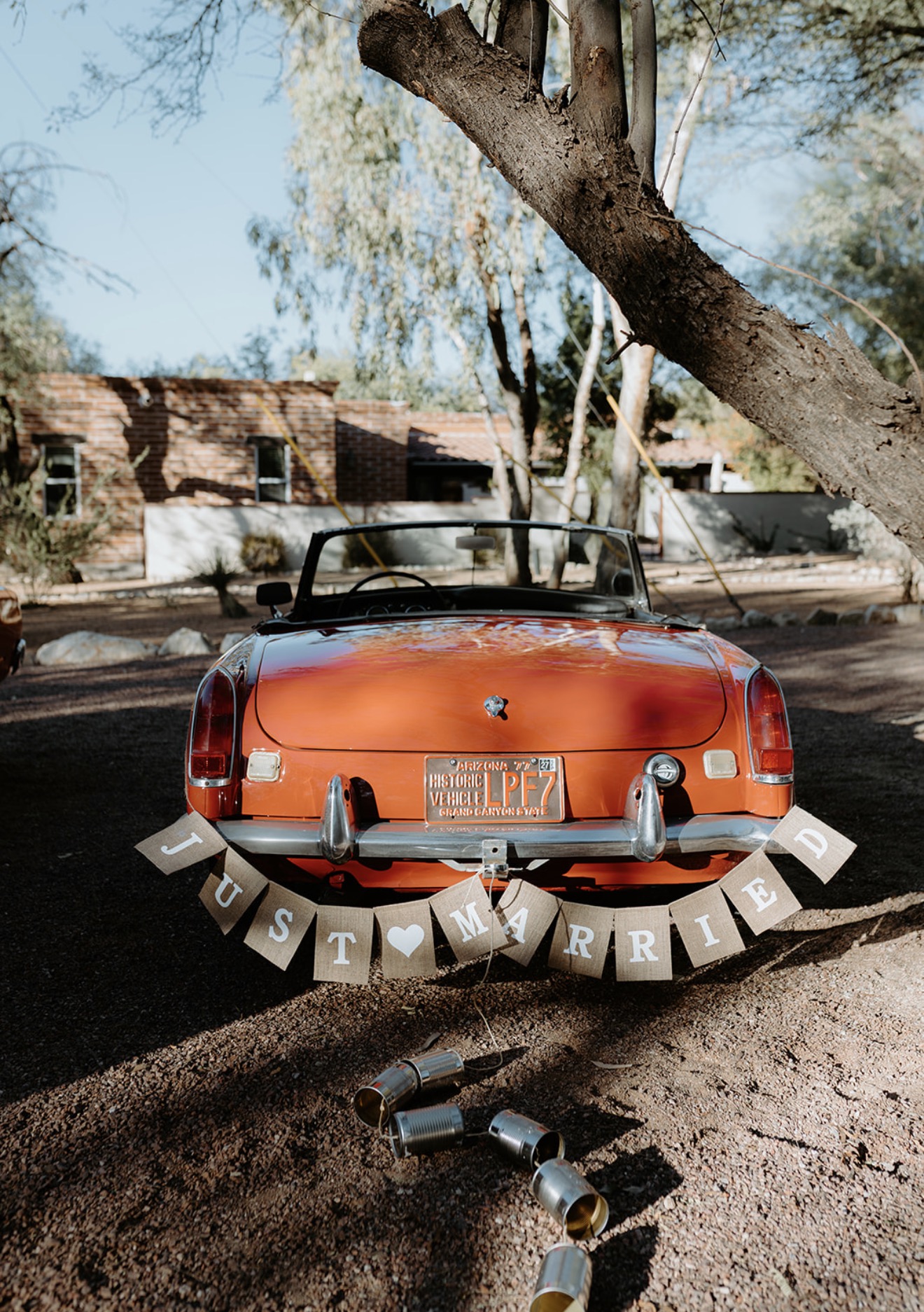 Rear of the maroon 1968 MG MGB Roadster decorated with a Just Married banner